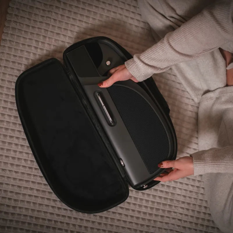 LiberLive C1 portable smart guitar being placed inside a carrying case on a bed.