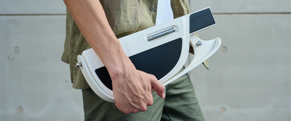 A person is holding a folded Liberlive guitar.