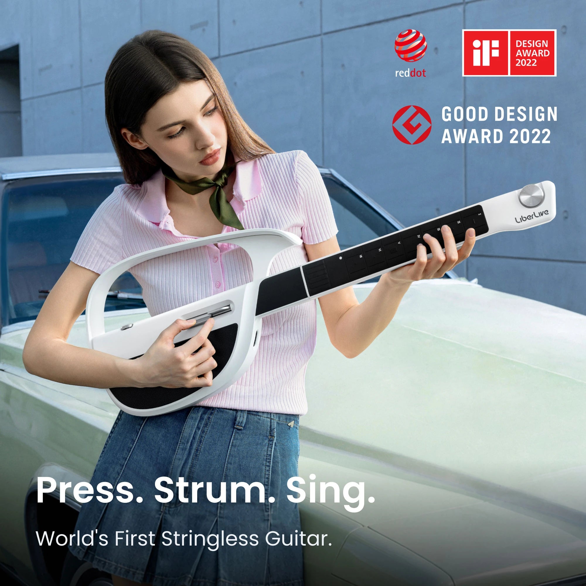 Woman playing a white LiberLive C1 stringless smart guitar beside design award badges.